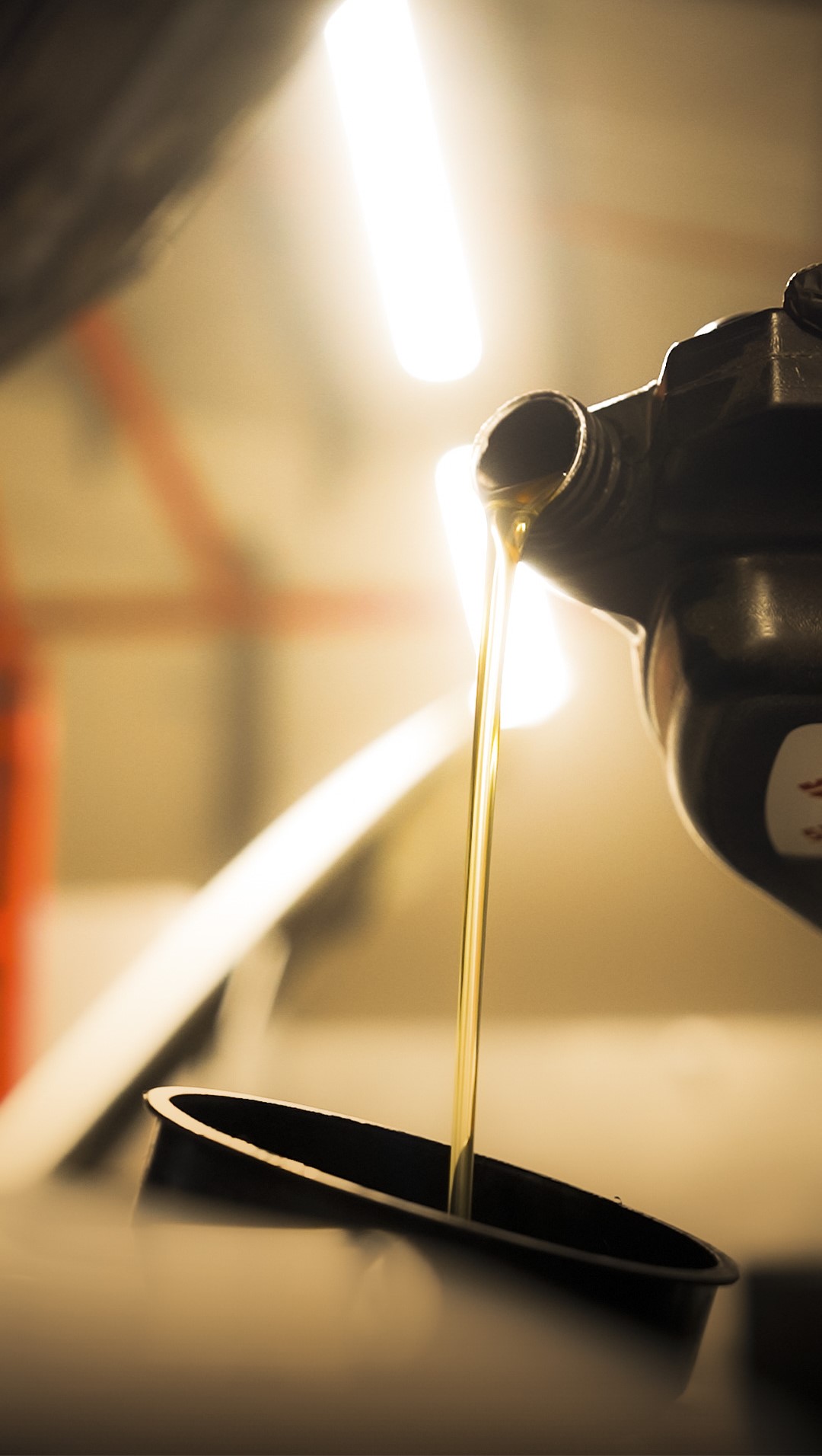 Oil pouring from a black bottle to a funnel