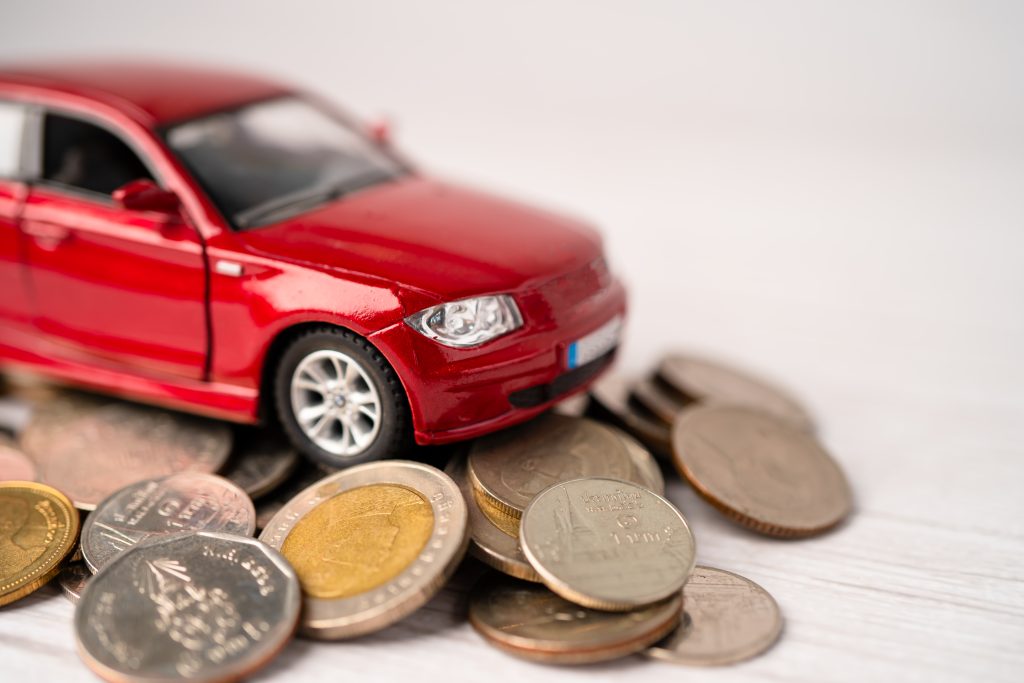 a small toy car on the top of few coins